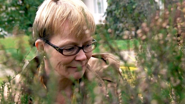Merja Korpua katselee istutuksia pihallaan.