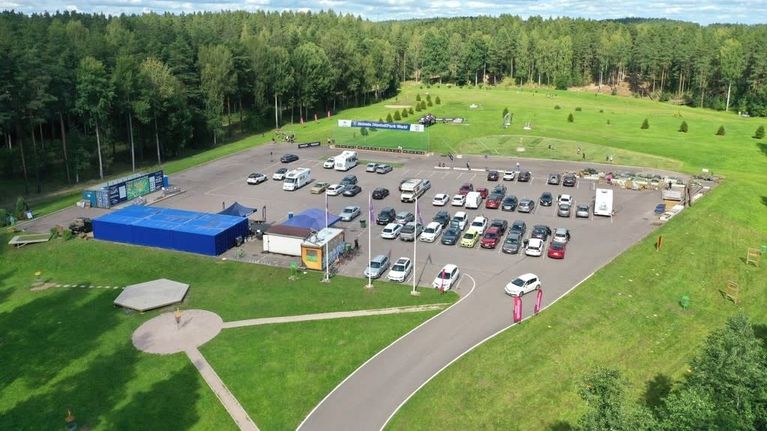 Ilmasta otetussa kuvassa näkyy parkkipaikka ja sen ympärillä nurmikkoalueita sekä puita.