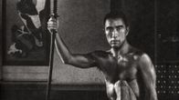 Japanilainen kirjailija Yukio Mishima istuu miekka kädessään.