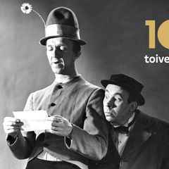 Pekka Puupää (Esa Pakarinen) kukkahatussaan lukee kirjettä ja Pätkä (Masa Niemi) katsoo olan yli, kuvassa teksti 100 toive-elokuvaa.