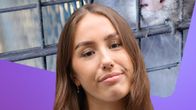 Reporter Isabella Biorac Haaja står framför en bild av en mink i bur på en pälsfarm.