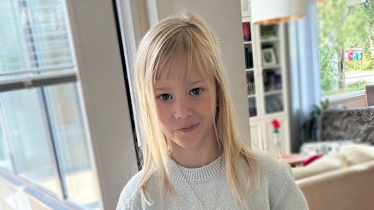 en skolficka visar upp sin ryggsäck.