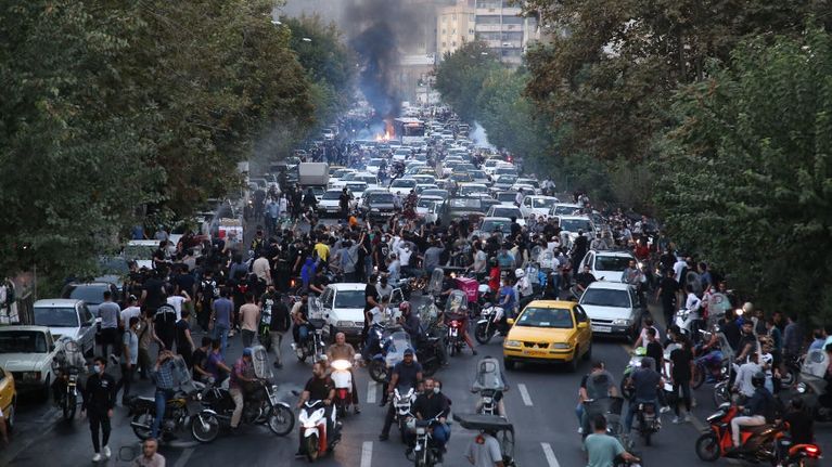 Demonstranter och polis drabbar samman under en protest i Irans huvudstad Teheran.