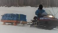 moottorikelkka ja reki, jossa iso nuuskalasti