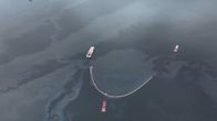 Veneitä järvessä, jossa on öljylauttoja. Kuva otettu ylhäältä.