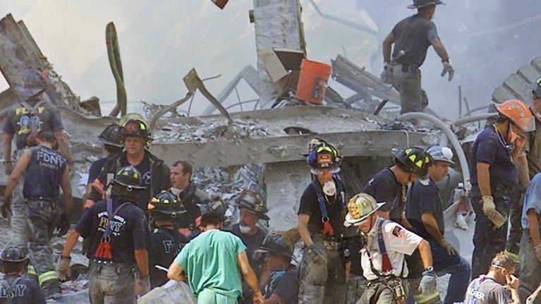 Yhdysvaltain lippu raunioiden keskellä, jossa pelastajat etsivät selviytyneitä syyskuun 11. terrori-iskujen jälkeen New Yorkissa vuonna 2001