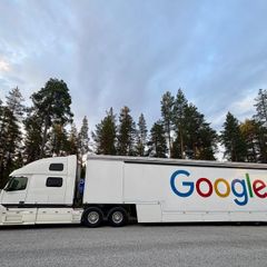 Long white lorry with Google printed in big colourful letters on the side of the truck.