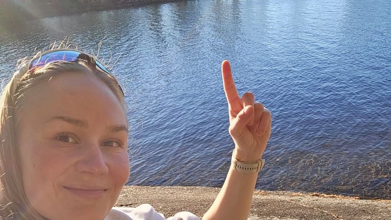 Jenni Rossi osoittaa sormella rantaa, josta villisika lähti uimaan.