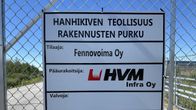 Verkkoaitaan kiinnitetty kyltti, joka kertoo Hanhikiven teollisuusrakennusten purkamisesta.