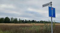 Kesantotie-kyltti ja tien päättymistä kuvaava liikennemerkki pellon laidalla.