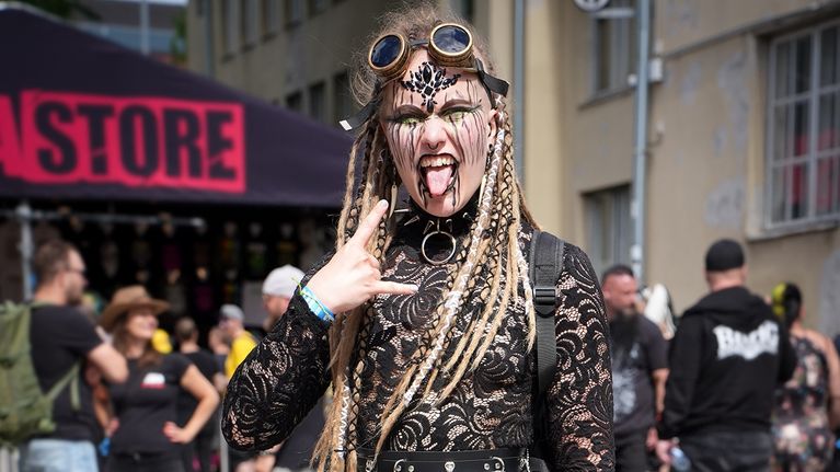 A young blonde woman in a black lace steampunk-style outfit.