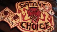 Mustalla alustalla tunnus, jossa on pirun kasvot ja teksti: Satan's Choice Helsinki.