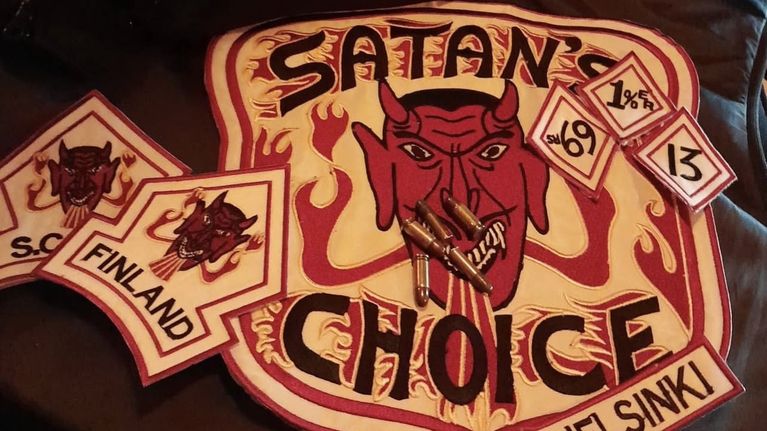 Mustalla alustalla tunnus, jossa on pirun kasvot ja teksti: Satan's Choice Helsinki.