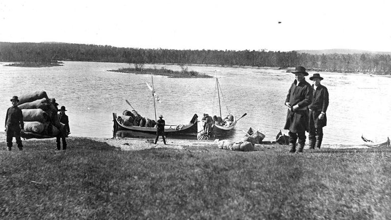 Saamelaisia Inarinjärven rannalla purjeveneillä.