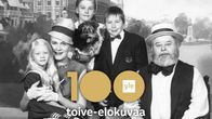 Kiljusen herrasväki poseeraa perhepotretissa, taustalla Esplanadi ja Runebergin patsas Helsingissä.