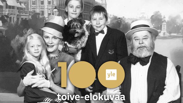Kiljusen herrasväki poseeraa perhepotretissa, taustalla Esplanadi ja Runebergin patsas Helsingissä.
