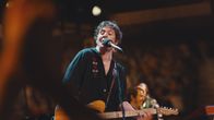 Bild ur filmen Springsteen: Deliver Me from Nowhere där Jeremy Allen White spelar Bruce Springsteen; på bilden White med en gitarr på en scen.