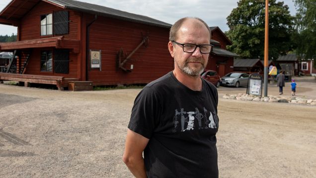 Hamnvärd Niclas Mattsson står vid Skeppsbron i Lovisa. Han har på sig en svart t-skjorta och tittar in i kameran med händerna bakom ryggen.