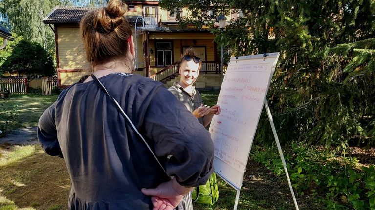 Talkoisiin saapuneita fläppi-taulun edessä.