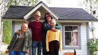 Fyra personer framför en lekstuga
