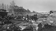 Lapuan patruunatehtaan räjähdyksen raunioita 13.4.1976. Pelastusmiehet istuvat patruunalaatikoilla onnettomuuspaikalla.