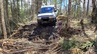 Kuvassa maastoauto metsässä.
