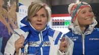 Kaksi naista Suomen olympiajoukkueen sinivalkoisissa vaatteissa näyttävät jännittävän urheilukilpailua.