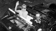 Marilyn Monroe ja Arthur MIller istuvat avoauton kyydissä.