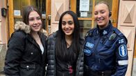 Kaksi Puolalan koulun opiskelijaa sekä poliisinainen poseeraavat some-kuvaa varten, taustalla koulurakennuksen ovi.
