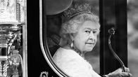 Drottning Elizabeth II i en vagn. Bilden är svartvit.