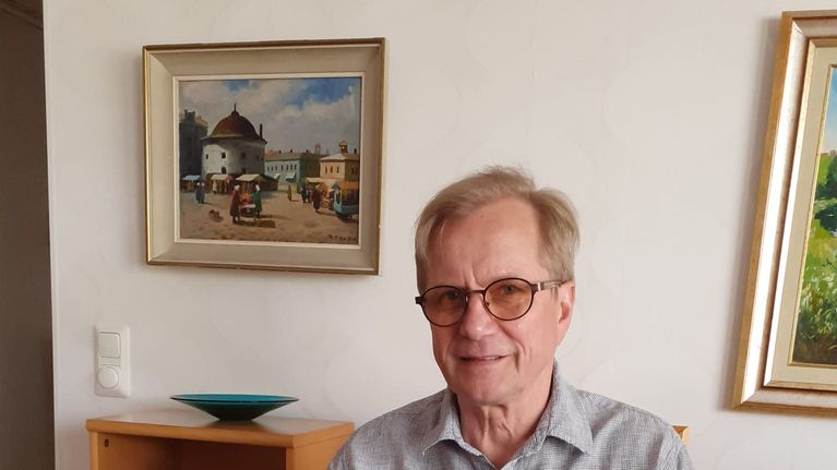 Mies pitää kädessään Ipadia ja katsoo suoraan kameraan. 