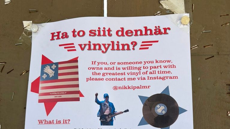 En affisch sitter upptejpad på en trävägg med rubriken "Ha to siit denhär vinyln?" samt kontaktuppgifter och bilder på en skiva och en person.