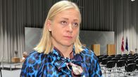 Elina Valtonen intervjuas av Yle. I bakgrunden syns ens konferenssal med talarpodium och många tomma stolar.