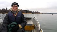 Veneilijä liikkuu rauhallisella vesistöllä syksyisessä maisemassa.