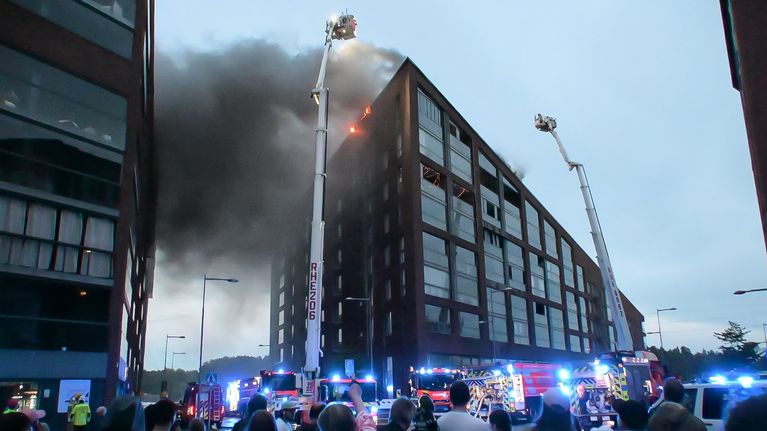 Smoke billowing from an apartment building. 