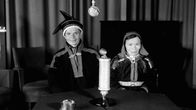 Saamelaispukuiset mies ja nainen istuvat radion studiopöydän takana.