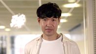 Kirjailija Quynh Tran seisoo sisätilassa ja katsoo kameraan.