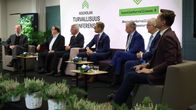 Seitsemän presidenttiehdokasta istuu tenttilavalla.