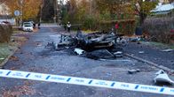 Räjähdyksessä tuhoutunut auto kadulla.