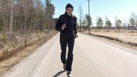 En äldre man tränar i träningskläder längs en landsväg