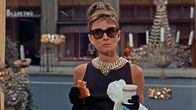 Audrey Hepburn syö aamiaistaan kultasepänliike Tiffanyn näyteikkunan ääressä elokuvassa Aamiainen Tiffanylla