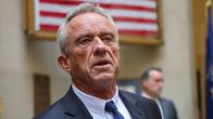 Presidenttiehdokas Robert F. Kennedy Jr. lähikuvassa, taustalla taulu, jossa on Yhdysvaltain lippu. 
