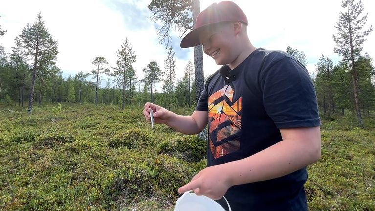 Poika pitelee uistinta hillajängällä ja hymyilee.