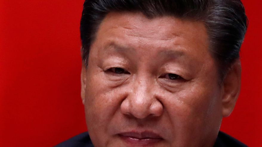 Tiiviissä lähikuvassa yrmeä Xi Jinping. Tausta kirkkaan punainen. 