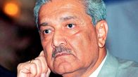 Abdul Qadeer Khan on kuvassa vaaleanharmaassa puvuntakissa ja punaisessa kravatisa. Hänellä on viikser ja harmaantuneet hiukset.