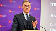 Presidentti Alexander Stubb puhujakorokkeella. Taustalla seinä, jossa London School of Economicsin logoja.