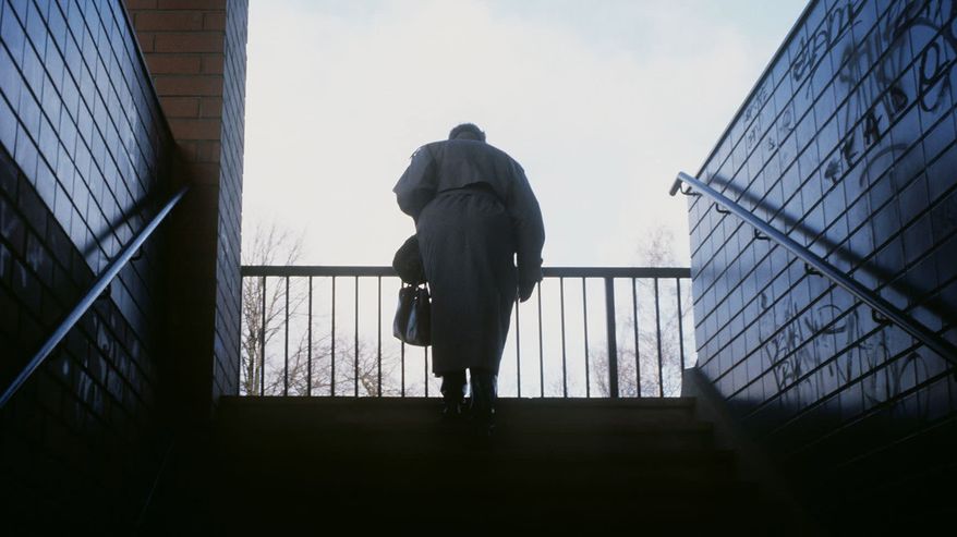 Vanha nainen kävelee portaita ylös helmikuussa 1990.