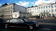 Suomenlipulla varustettu auto presidentinlinnan edustalla