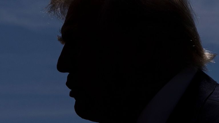 Trump vastavalokuvassa, näkyy siluetti. 