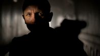 Daniel Craig James Bondin roolissa elokuvassa Skyfall. Osoittaa pistoolilla eteensä varjot kasvoillaan.